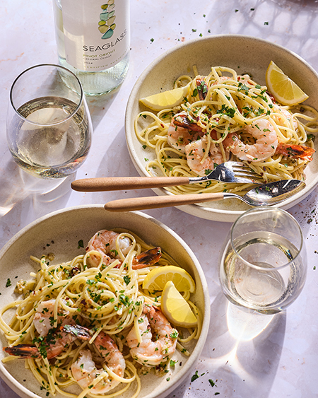 Two bowls of Garlic Shrimp Scampi with a glass of SEAGLASS Coastal Wine